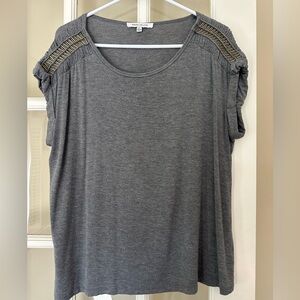 Gray top with metal detailing at the shoulders